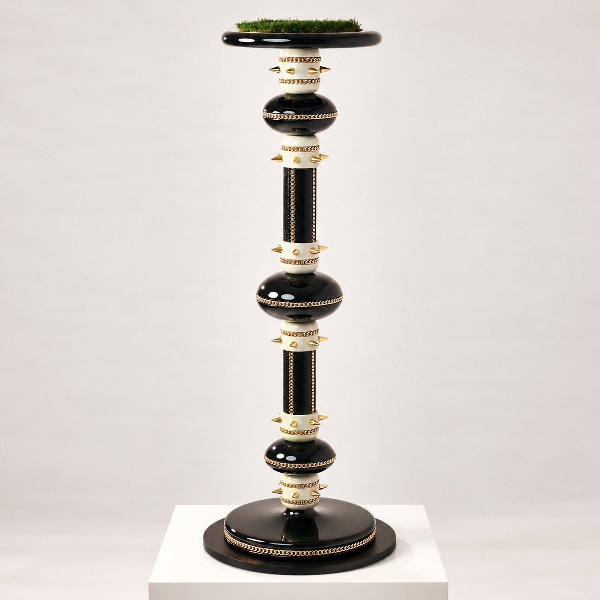 VICTORY, The Zenith Monolith Falcon Perch by FUROAR, featuring a towering black and ivory architectural form with gold chain detailing, sculptural accents and a grass-topped falcon platform.