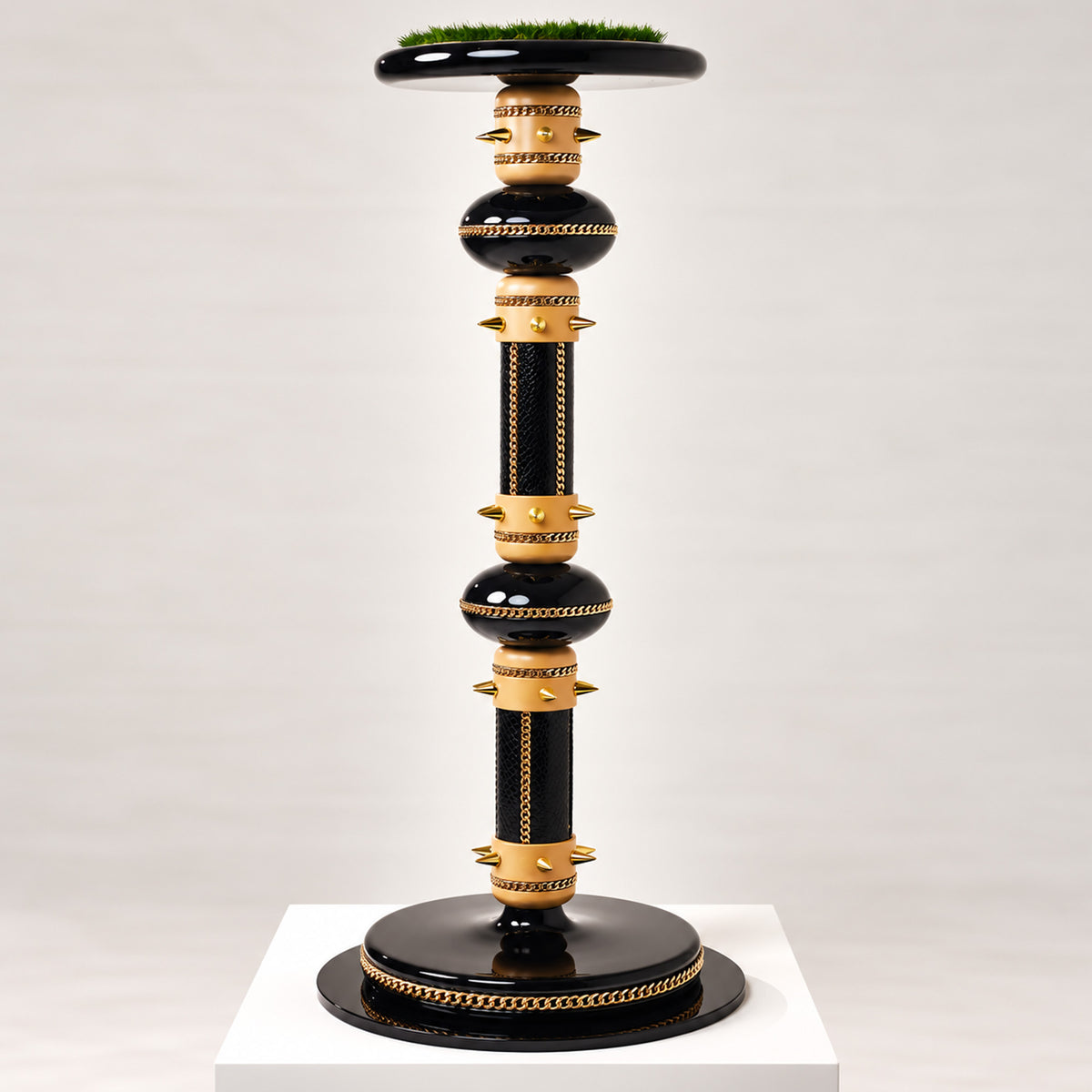 ARCHON, The Crowned Pedestal Falcon Perch by FUROAR, featuring a sculptural black and warm gold design with polished chain detailing, gold accents and a grass-topped falcon platform.