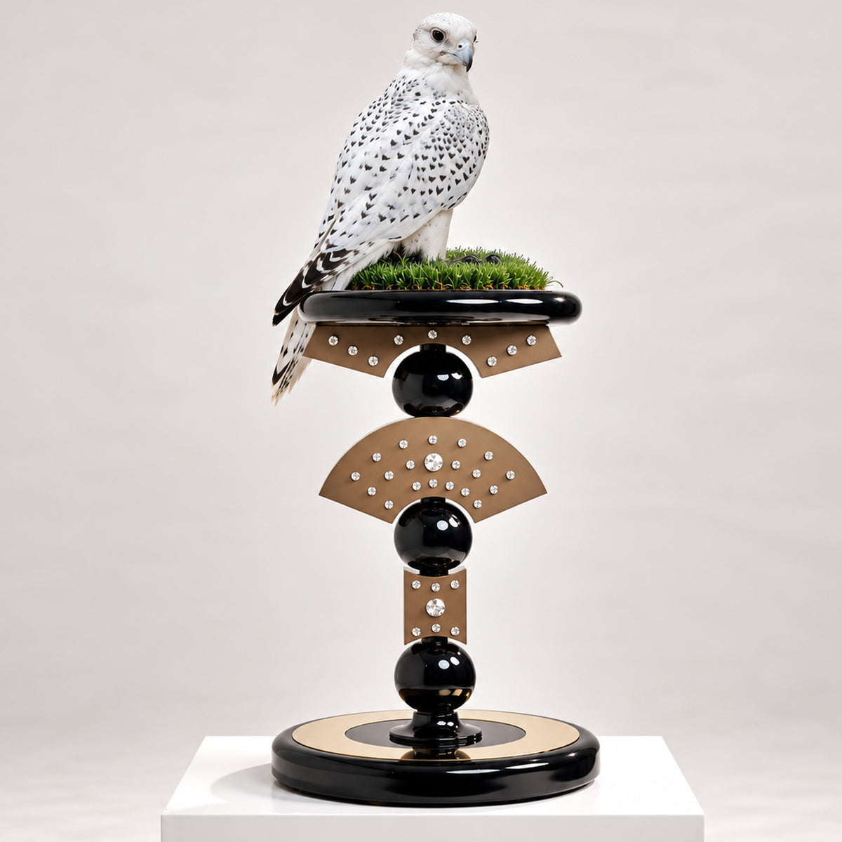 Queen, The Apex Falcon Perch by FUROAR, featuring a sculptural black and bronze design with crystal detailing, green grip grass and a white speckled falcon.