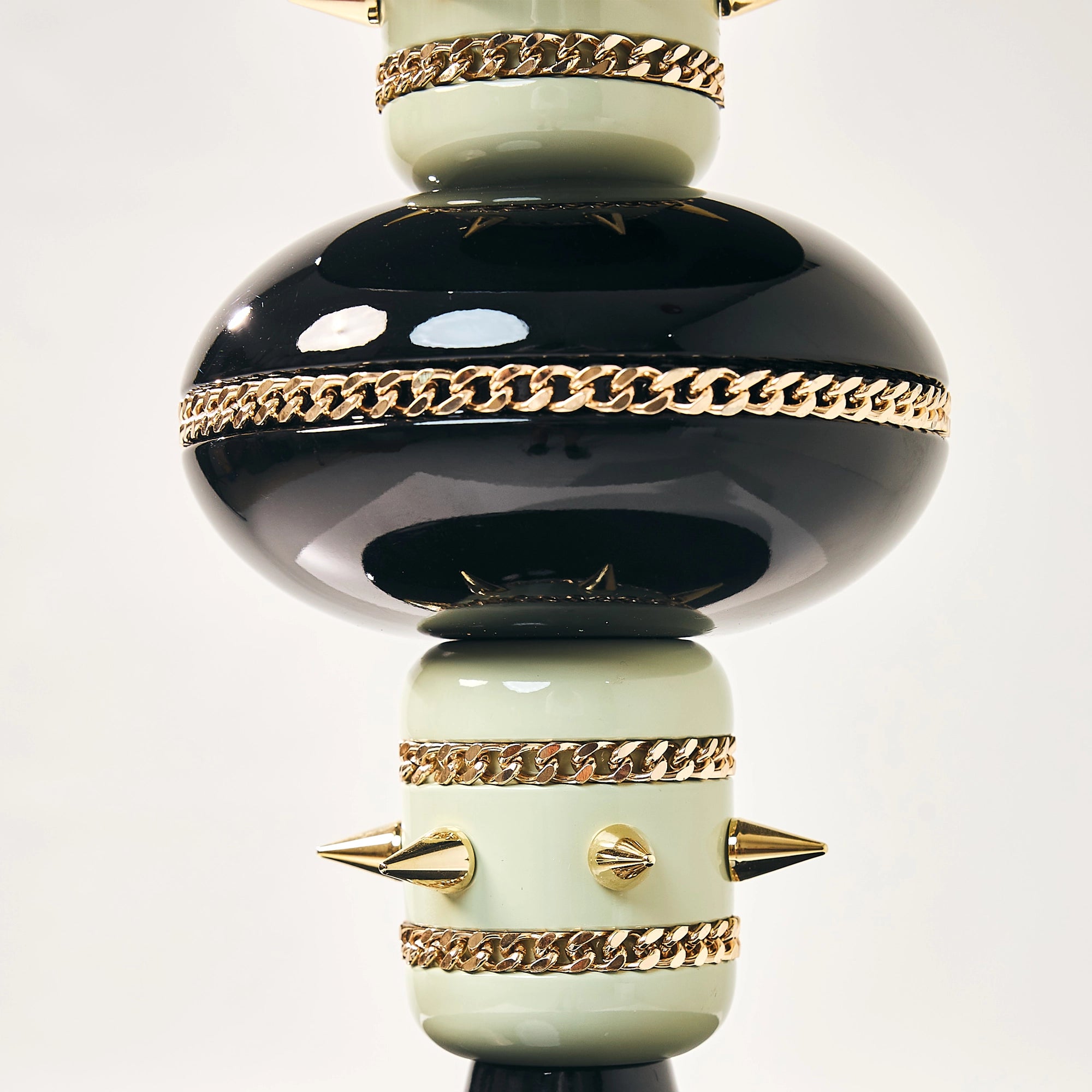 Detail of the glossy black sphere and spiked gold bands on the Skye falcon perch.