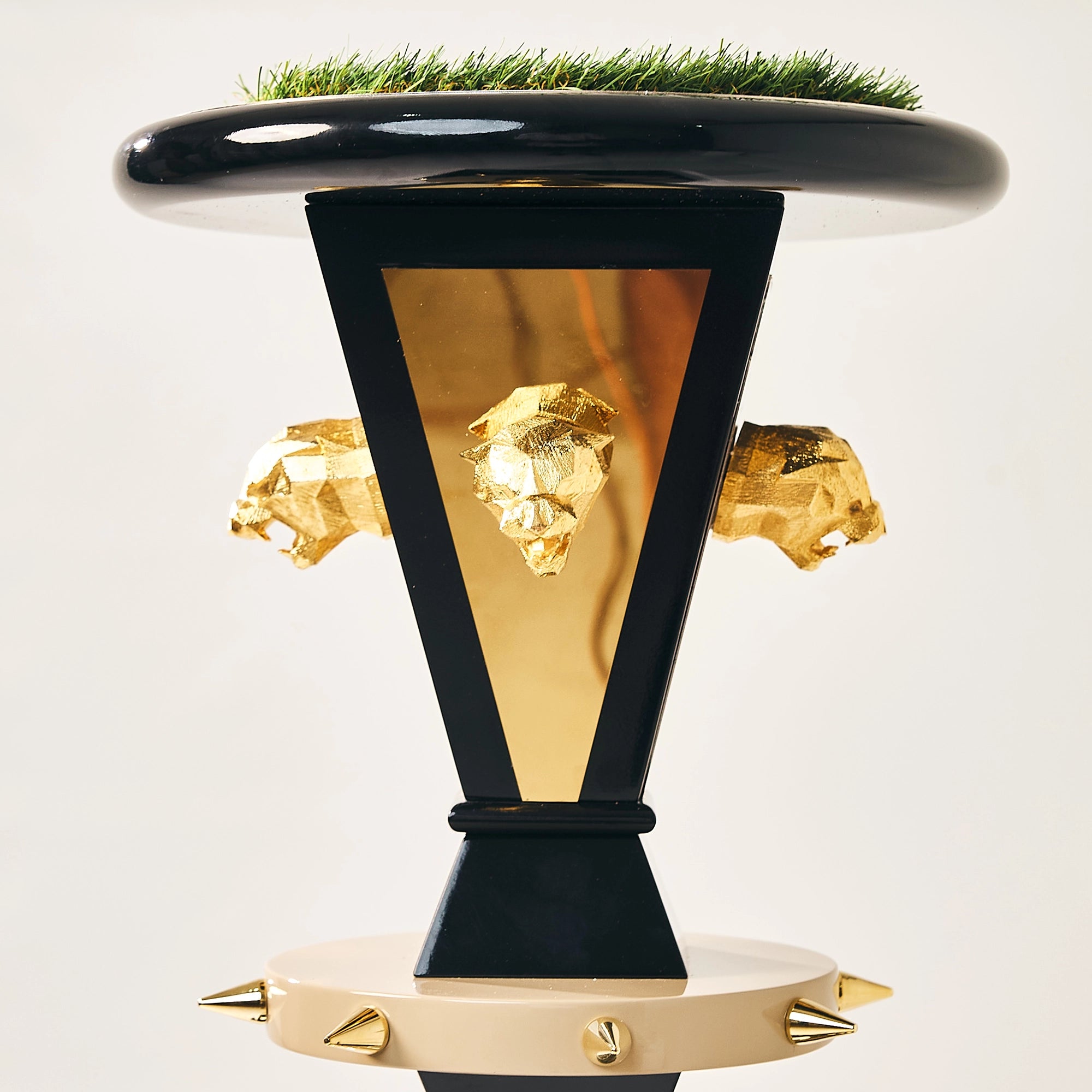 Close-up of gold jaguar heads on the upper column of the FUROAR Kaiser falcon perch.
