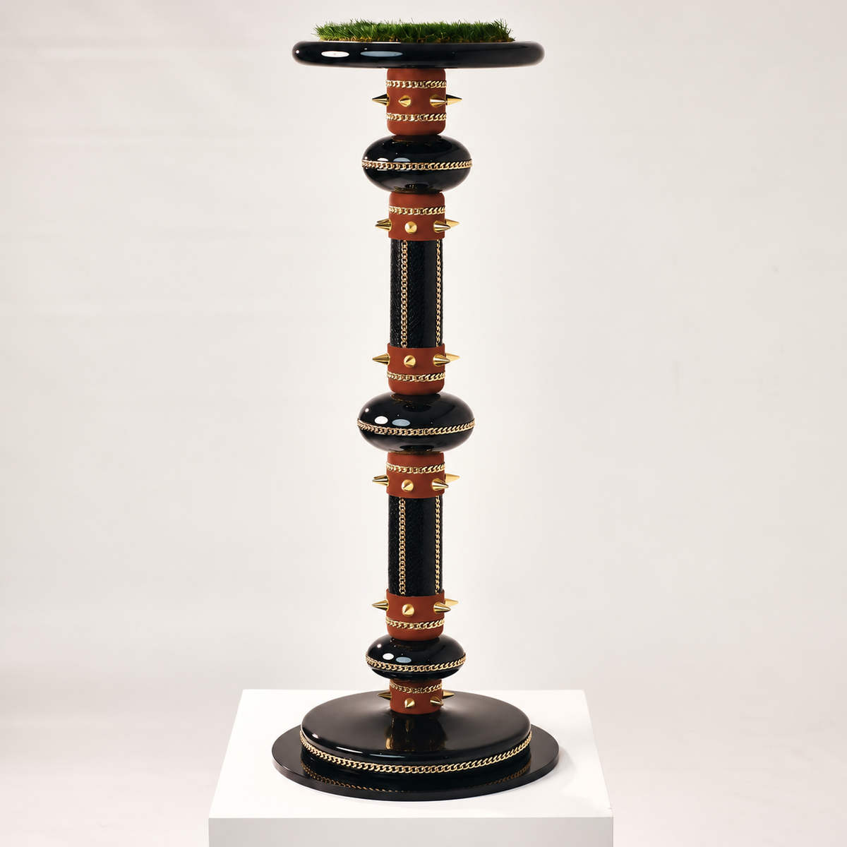 VICTORIA , The Zenith Monolith Falcon Perch by FUROAR, featuring a towering black and burgundy architectural design with gold chain detailing, sculptural accents and a grass-topped falcon platform.