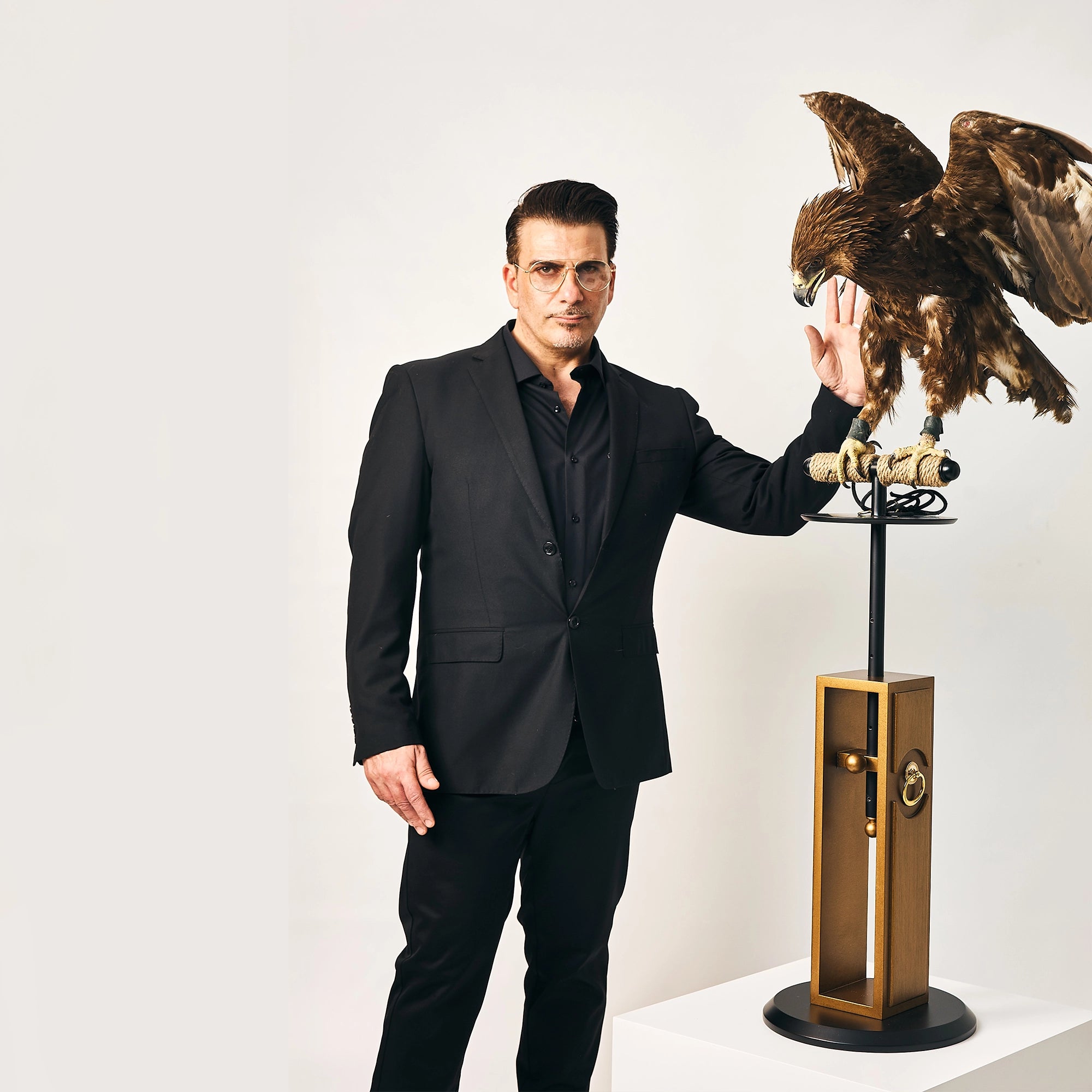 Jamal Hammoud next to a golden eagle perched on a luxury FUROAR Nobel falcon stand.